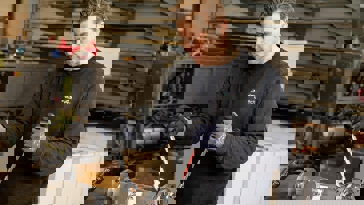 smed med værktøj i hånden der står på værkstedet hos Insatech