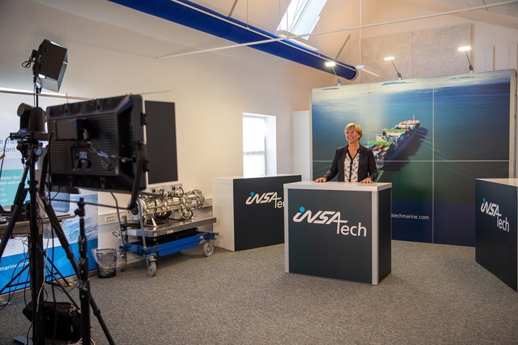 webinarholder bag insatech bord med synligt optageudstyr foran