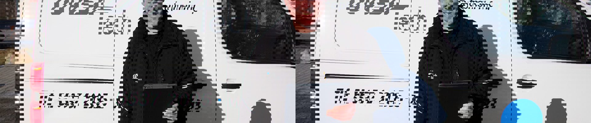 Insatech servicetekniker står foran bil med blå hjelm på